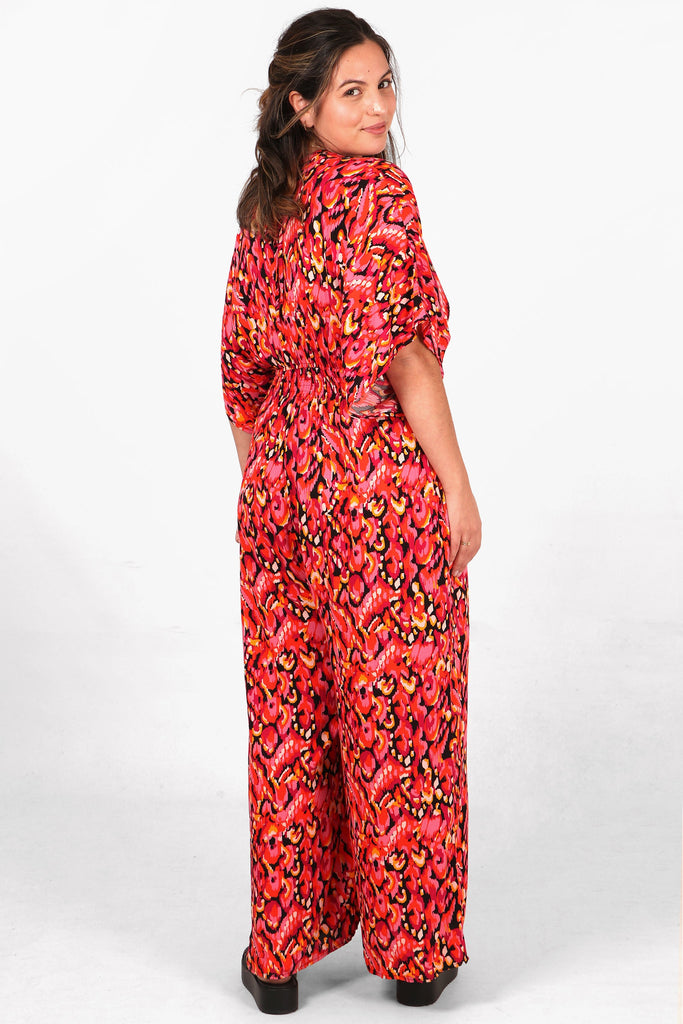 model showing the back of the jumpsuit, showing an all over pattern