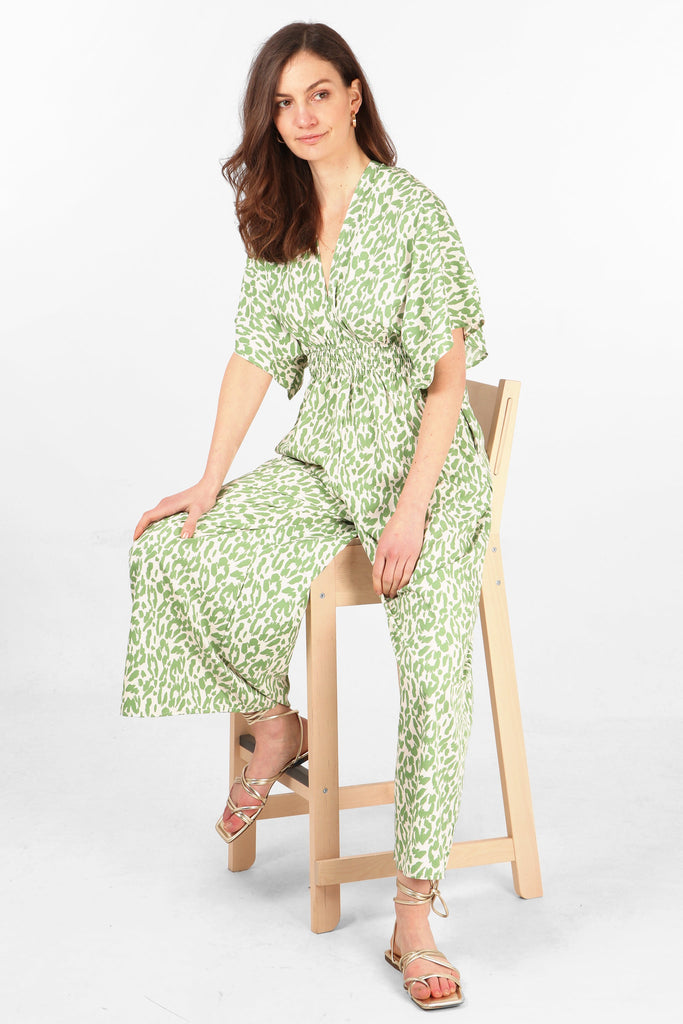 model wearing an olive green leopard print wide leg jumpsuit with short angel sleeves
