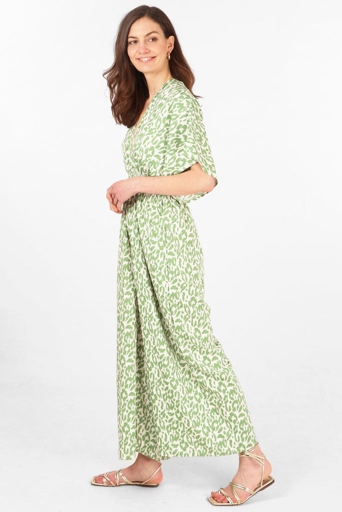 model showing the side view of the jumpsuit, showing the wide leg design and short angel sleeves