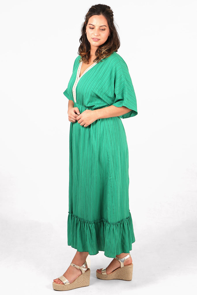 model showing the side view of the dress, highlighting the tiered trim and 3/4 sleeves