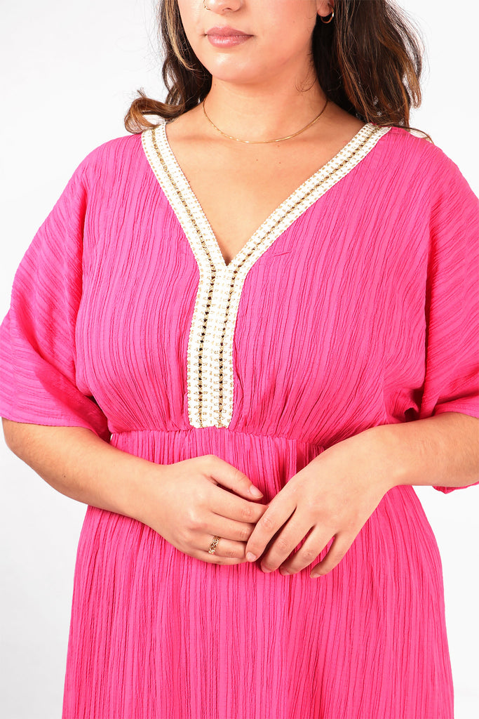 close up of the gold rope trim detail at the neckline, the dress has a v neck