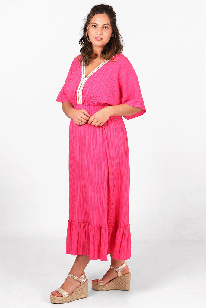 model showing the side view of the dress, highlighting the tiered trim and 3/4 sleeves