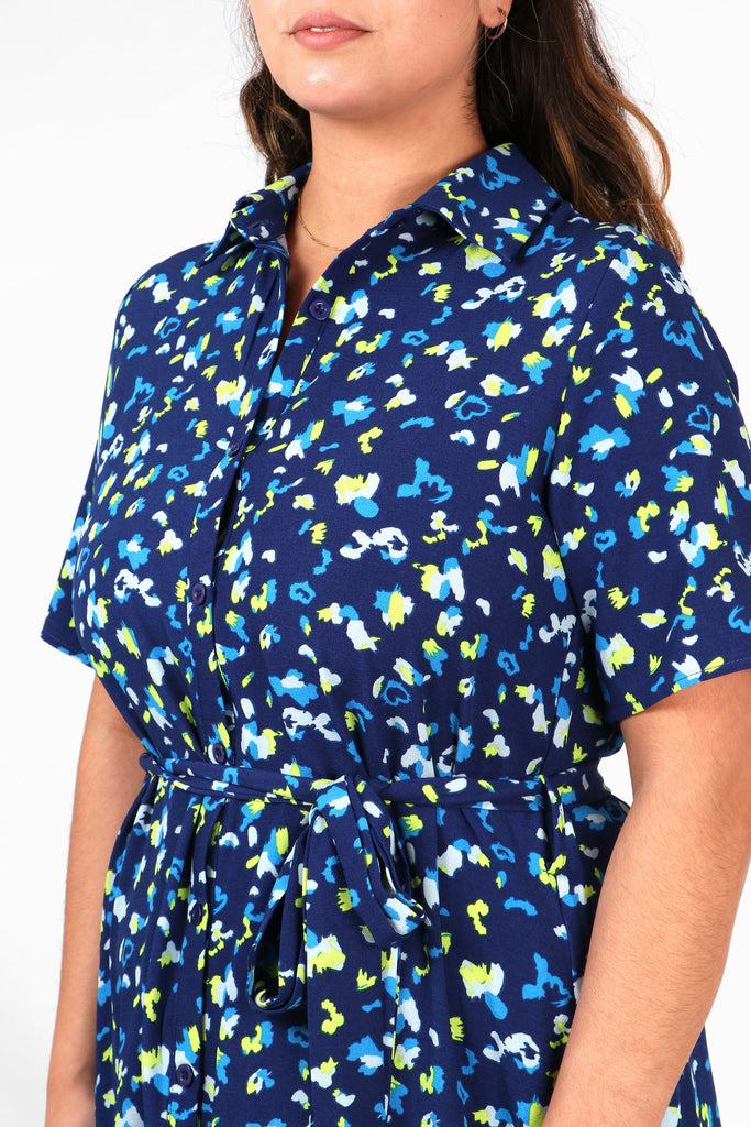 close up of the blue abstract print pattern and button down front fastening of the shirt dress