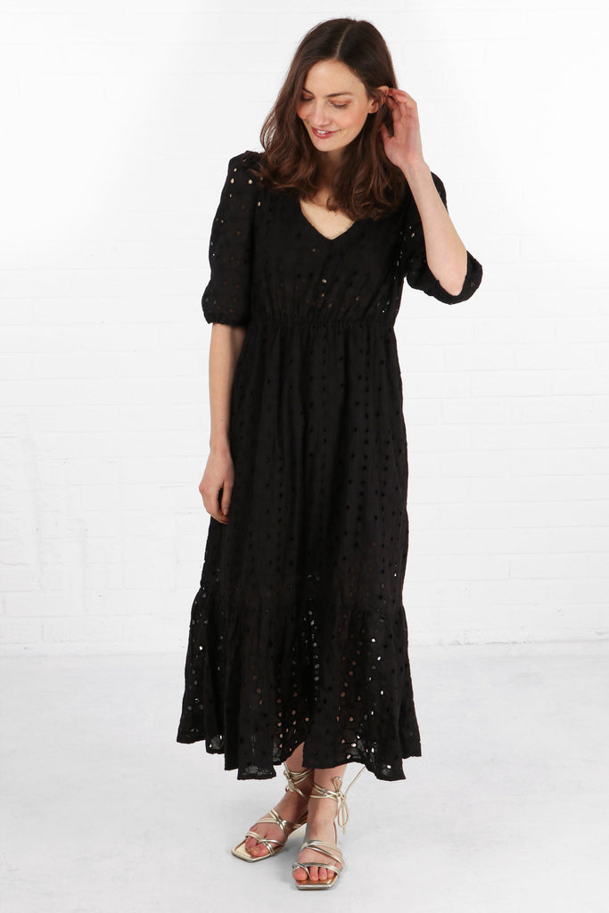 model wearing a midaxi length black broderie anglaise cotton dress with a v neck and elbow length puff sleeves