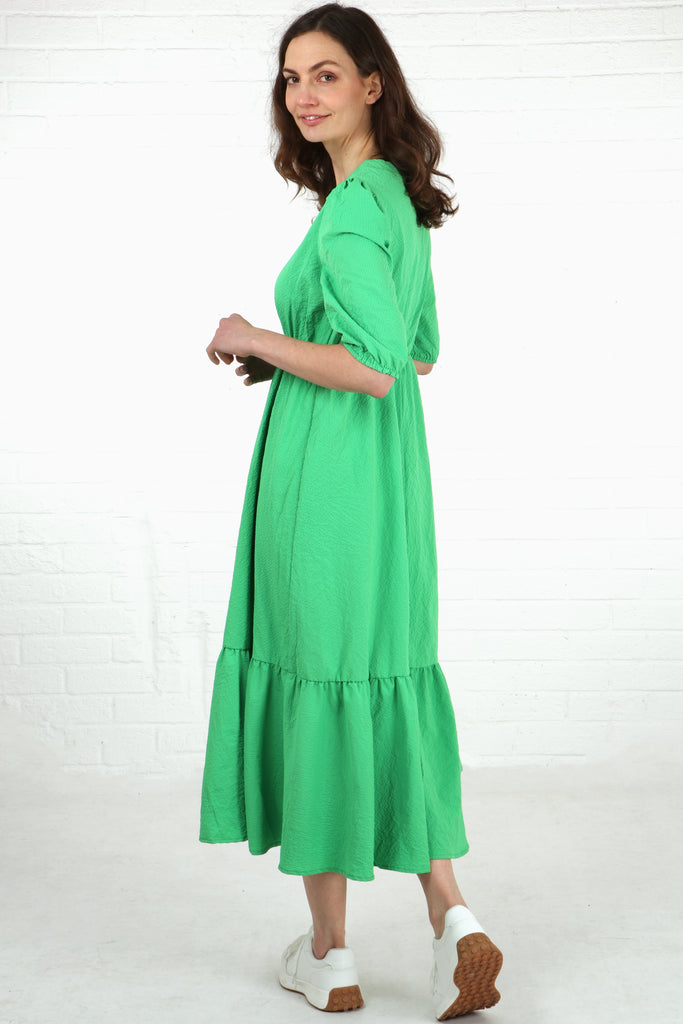 model showing the back of the dress with the textured material and tiered hem
