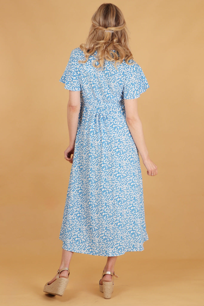 model showing the back of the dress and the all over ditsy floral print pattern
