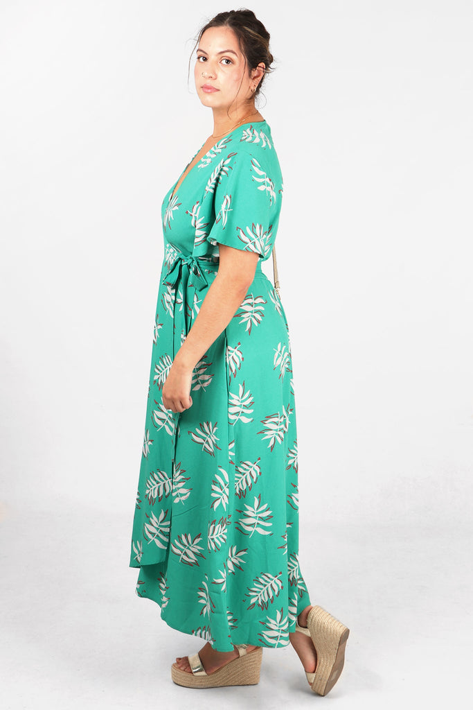 model wearing a midaxi length mint green wrap dress with short angel sleeves and waist tie fastening