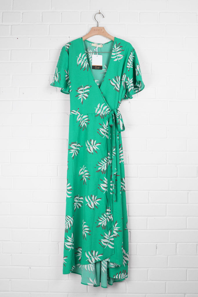 green leaf pattern wrap dress draped on a coat hanger