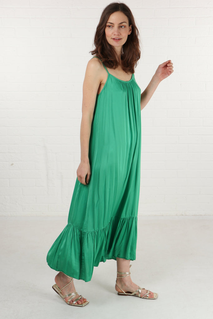 model wearing a loose fitting round neck green tiered maxi dress with thin shoulder straps