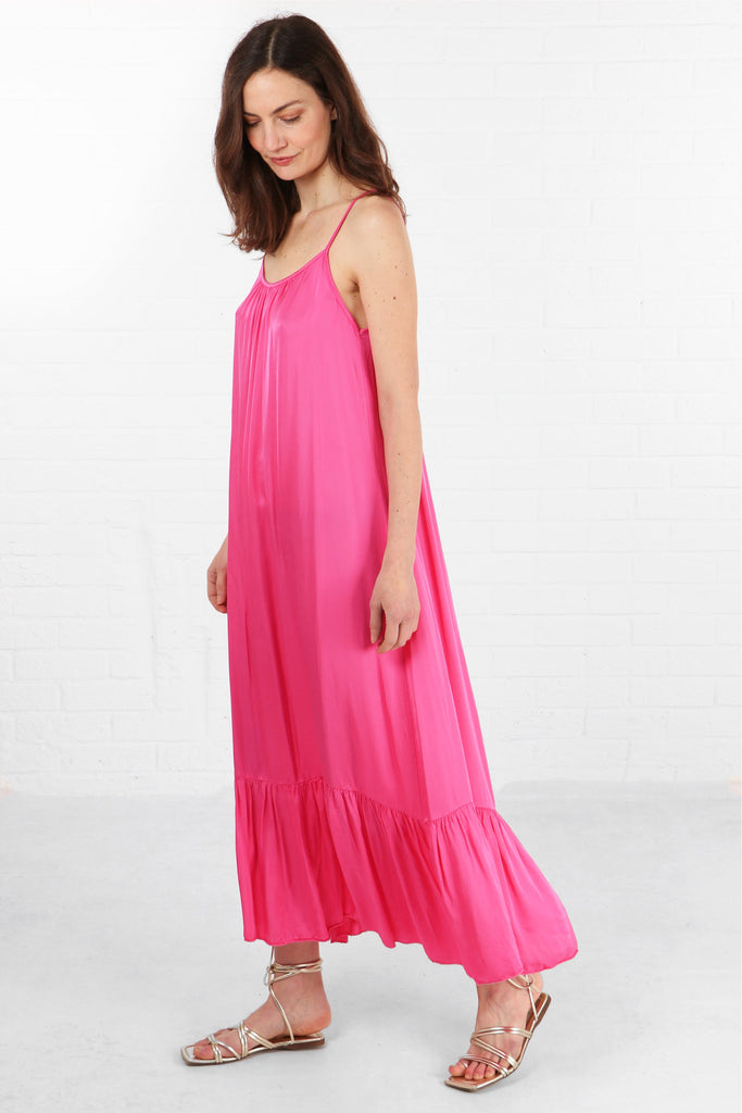 model wearing a loose fitting round neck pink tiered maxi dress with thin shoulder straps
