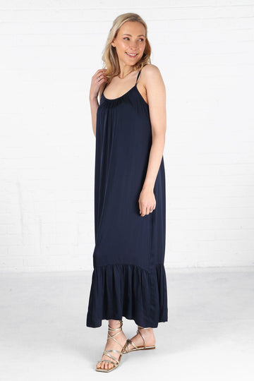 model wearing a navy blue tiered maxi dress with thin spaghetti staps