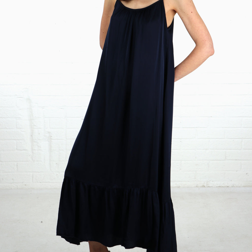 model wearing a navy blue strappy tiered maxi dress