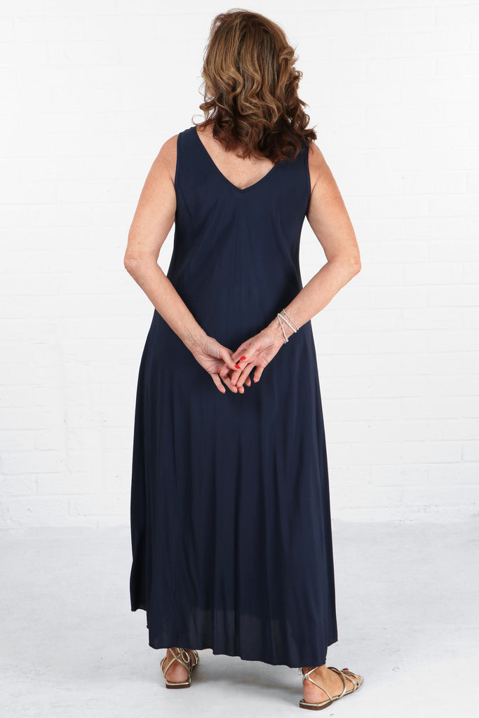 model showing the back of the dress which is the same solid navy blue colour as the front, v neck on the back as well as the front