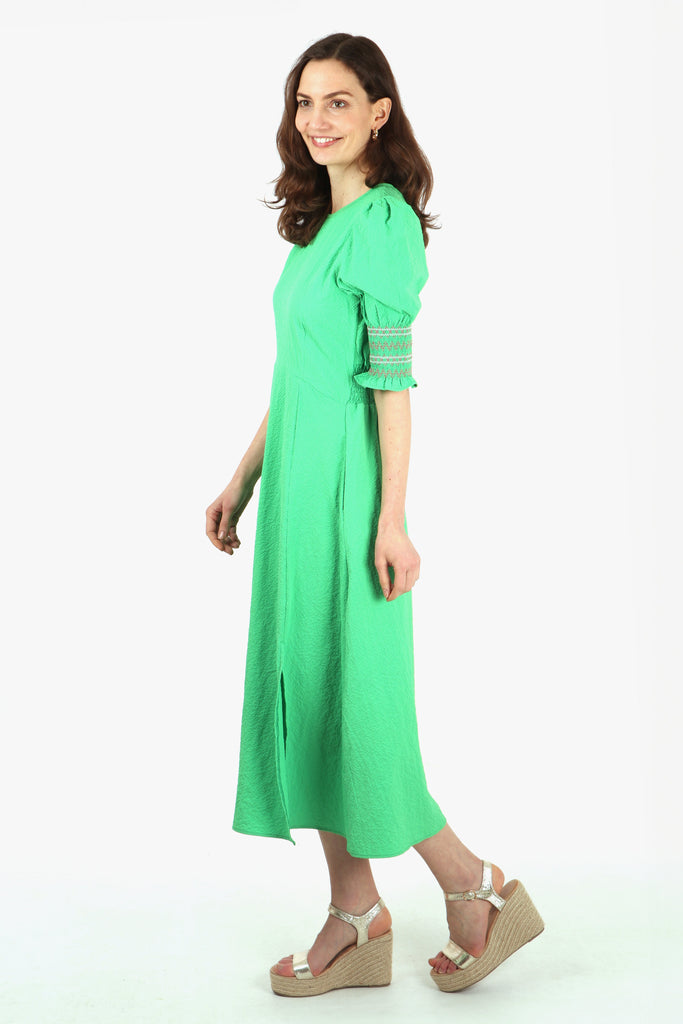 side view of the green tea dress, showing the modest front split and embroidered cuffs