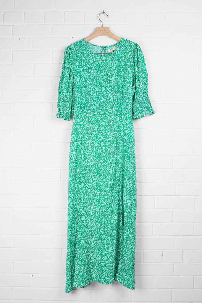 green ditsy floral tea dress draped on a coat hanger