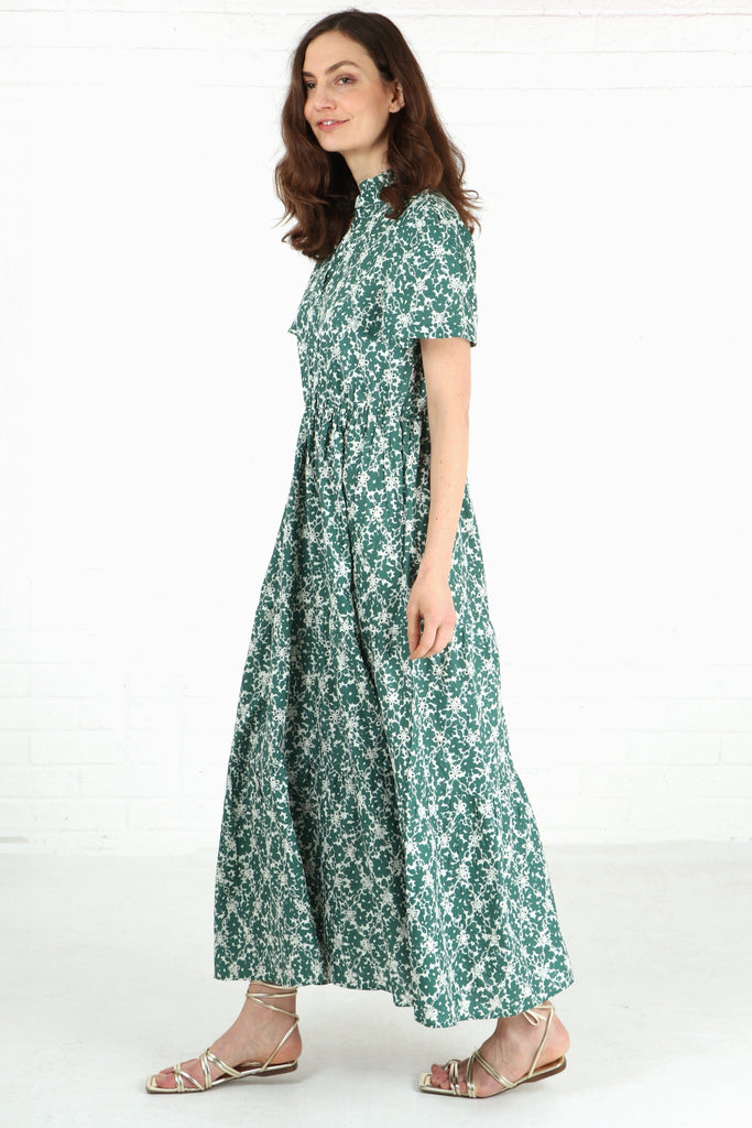model wearing a maxi length green and white tiered dress with short shirt sleeves 