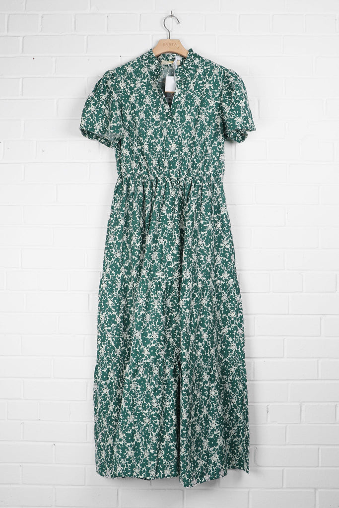 green and white floral broderie anglaise dress draped on a coat hanger