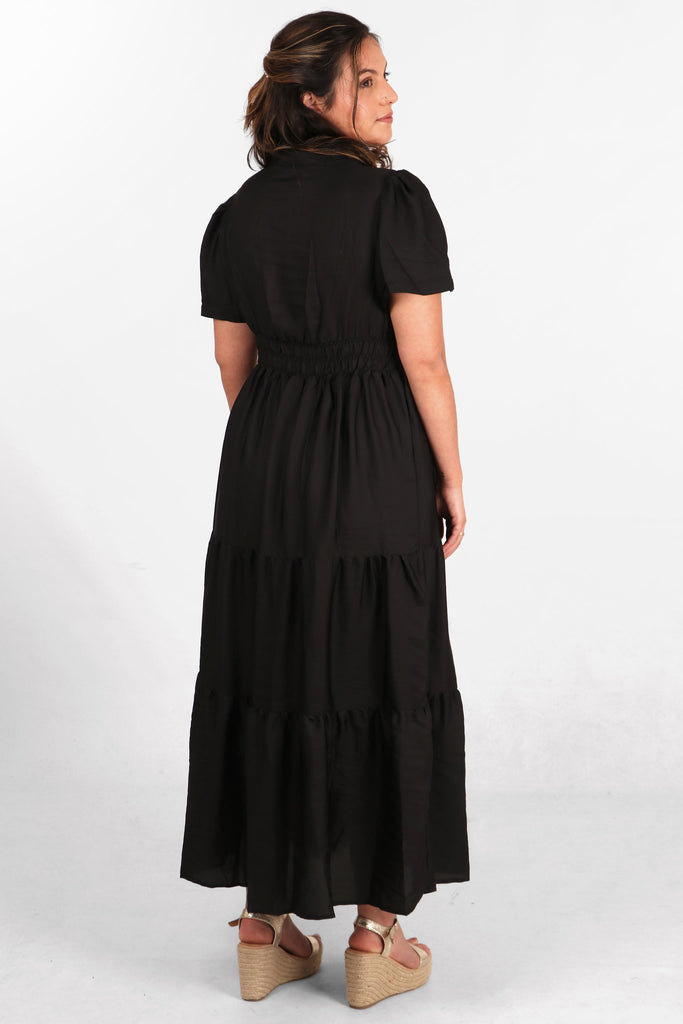 model showing the back of the dress, highlighting the elasticated waist and tiered design
