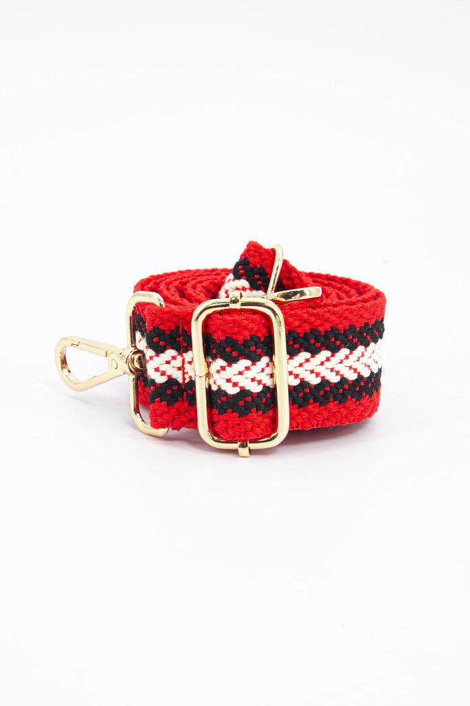 close up of the gold adjustment buckle on the red and navy blue contrasting chevron stripe bag strap