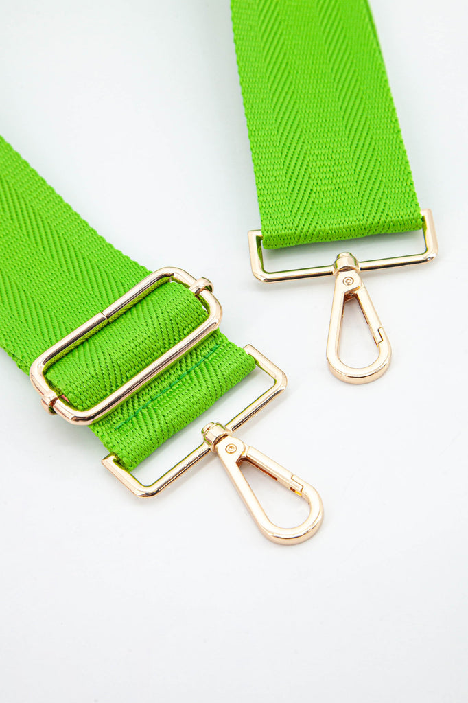 close up of the gold snap hook attachments and the bright lime green colour of the strap