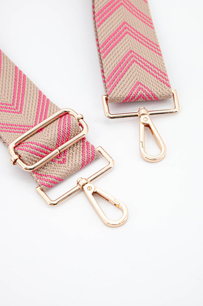  close up of the gold clip on snap hook attachments and the pink woven chevron material