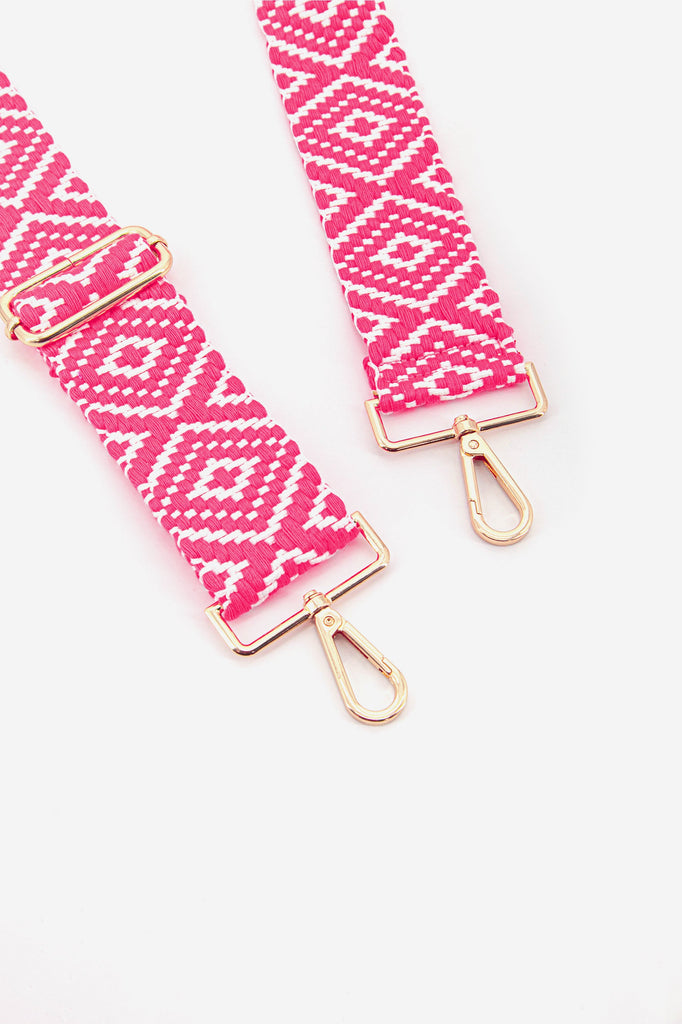 close up of the gold snap hook attachments on the pink bag strap