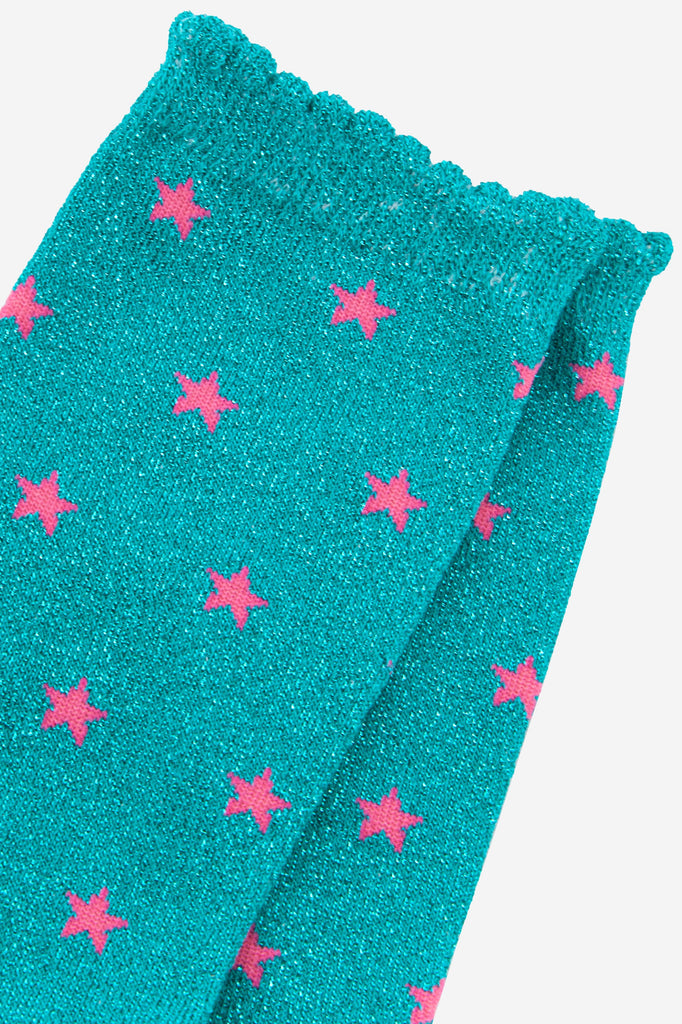close up of the pink star pattern on the blue glitter socks