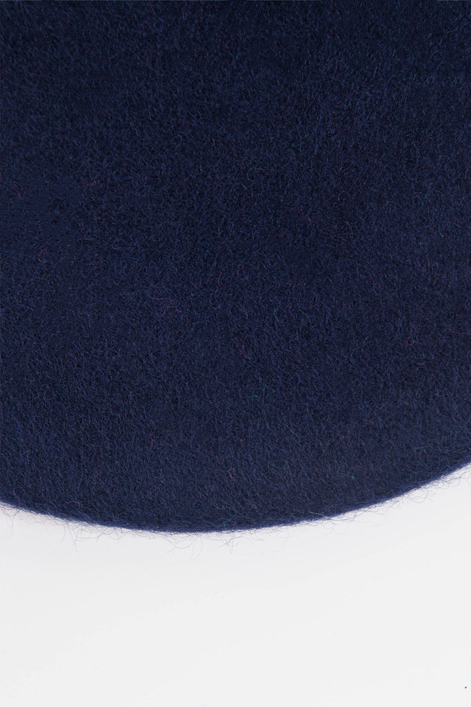 close up of the wool rich fabric and navy blue colour of the beret