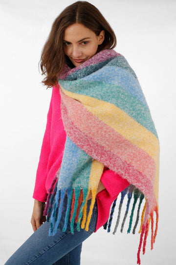 model wearing a colourful rainbow striped winter scarf around her neck and shoulders