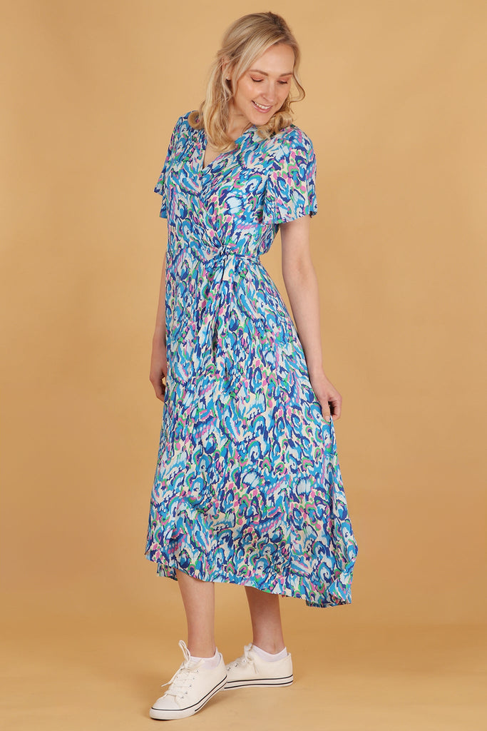 model showing the dipped hem design on this short sleeved wrap dress, the hem is a little longer at the back than at the front