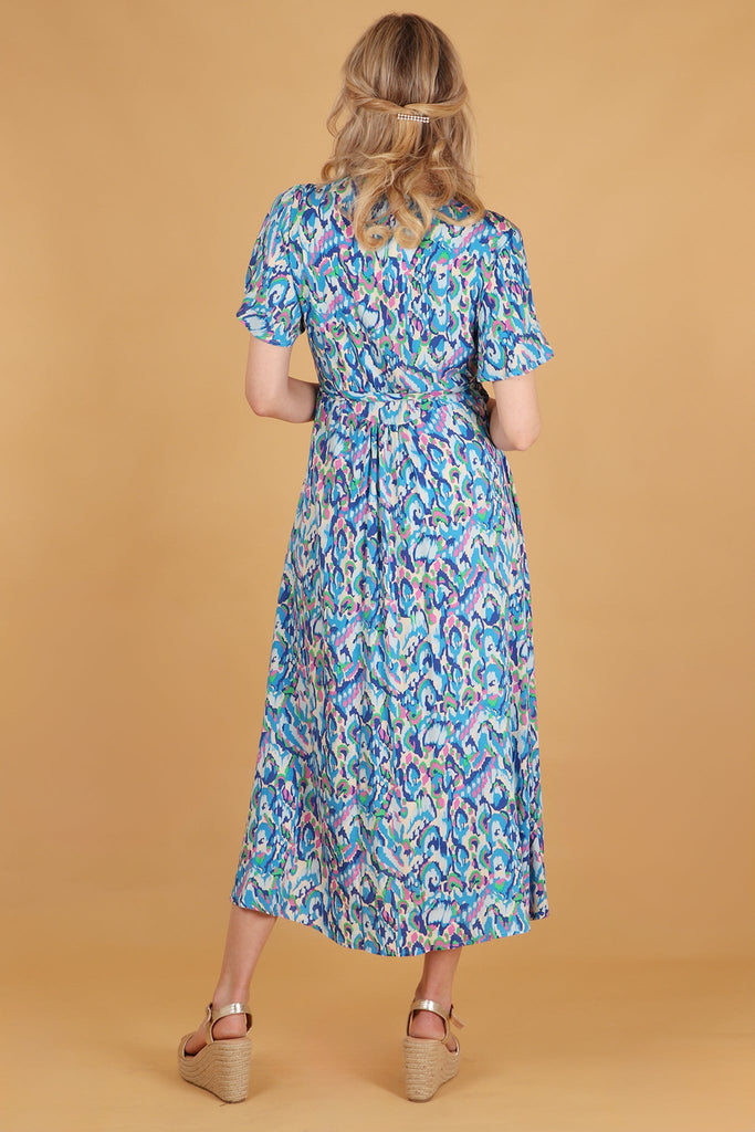 model showing the back of the dress with the all over abstact pattern