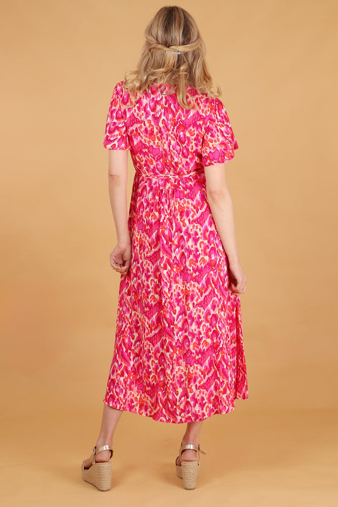 model showing the back of the dress with the all over abstact pattern