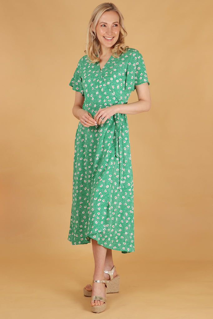 model wearing a green daisy print waist tie wrap dress with short sleeves